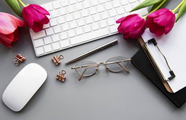 Üst kattaki ofis masasında yatıyordu. Çalışma alanı boş klavye, klavye, ofis malzemeleri, masa üzerinde kalem, lale.