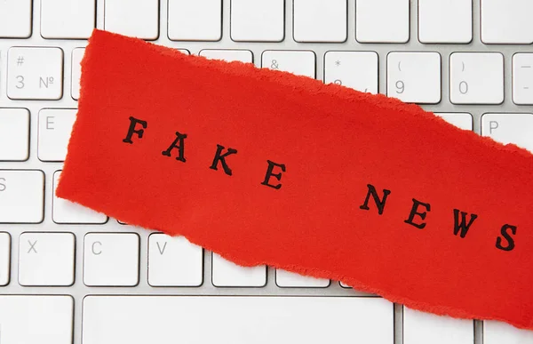 Woorden Fake News Geschreven Gescheurd Papier Een Toetsenbord — Stockfoto