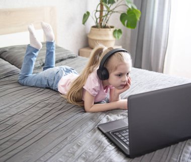 Liseli kız evde dizüstü bilgisayar kullanarak ders çalışıyor. Evde kal. Çevrimiçi eğitim, ev eğitimi, karantina kavramı.