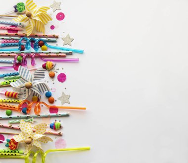 Mutlu yıllar ya da parti geçmişi. Doğum günü pipetleri, konfetiler ve beyaz arka planda şekerler. Üst Manzara. Boşluğu kopyala.