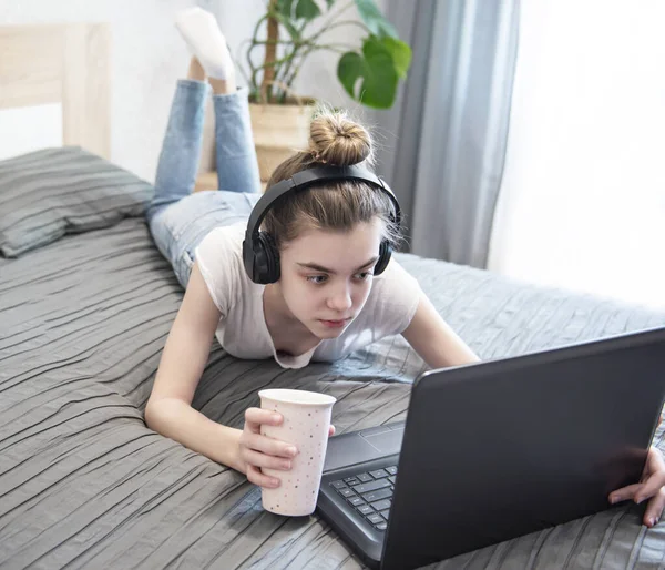 Schoolgirl studying at home using laptop. Stay at home. Online education, home education, quarantine concept.