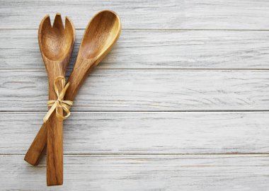 Tahta bir arka planda iki tahta salata kaşığı, düz yatıyordu.