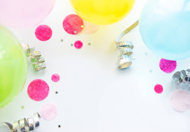 Mutlu yıllar ya da parti geçmişi. Beyaz arka planda doğum günü balonları, konfeti ve kurdeleleri olan düz yatış. Üst Manzara. Boşluğu kopyala.