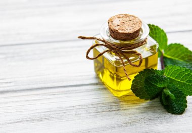 Ahşap zemin üzerinde nane aromalı gerekli aroma yağı..