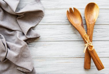 Eski mutfak gereçleri. Tahta kaşıklar, beyaz tahta masanın üzerine peçete. Üst görünüm