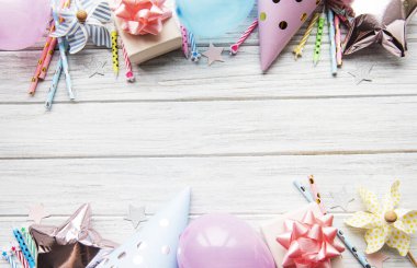 Mutlu yıllar ya da parti geçmişi. Doğum günü şapkaları, konfeti ve beyaz ahşap arka planda kurdeleler. Üst Manzara. Boşluğu kopyala.