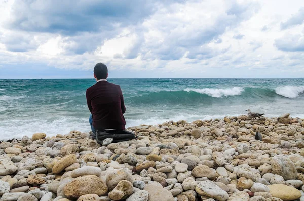 Denize yakın oturan bir adam