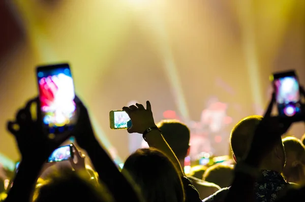 Bir konserde kalabalıkta insanlarla smartphons elinde