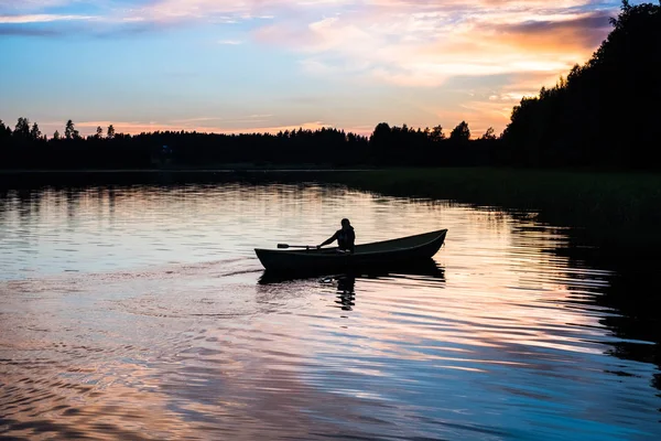 Homem flutuando em um barco em um lago — Fotografia de Stock