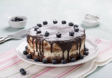 Ev yapımı katmanlı kek çikolata sosu ile mavi ile dekore edilmiştir.