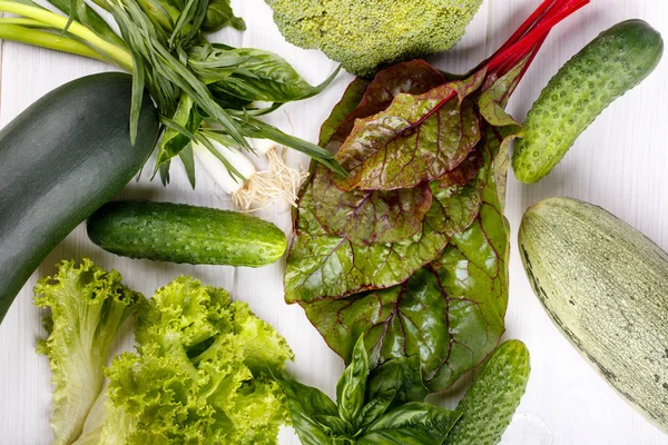 Verduras verdes no fundo de madeira branco — Fotografia de Stock