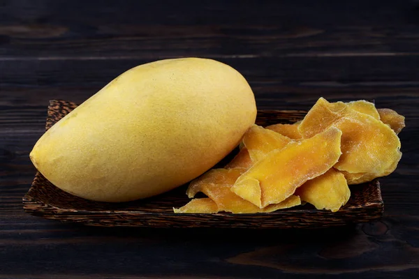 Fette di mango disidratate e mango fresco crudo su piastra di legno su d — Foto Stock