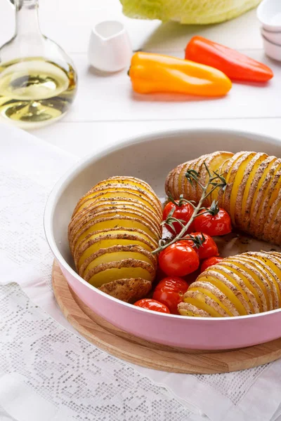 Запеченные картофель и помидоры на белом столе — стоковое фото