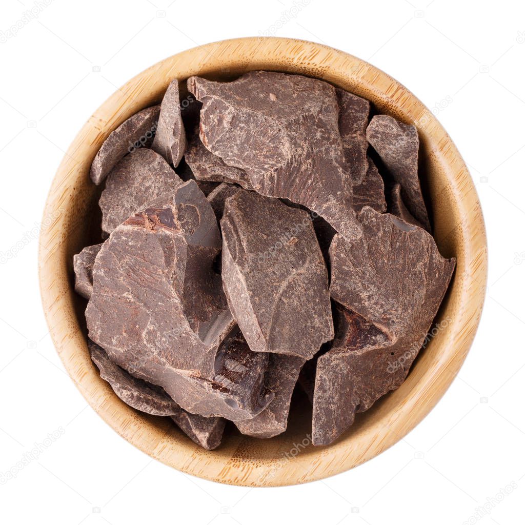 Cocoa mass in a wooden bowl isolated on white. 