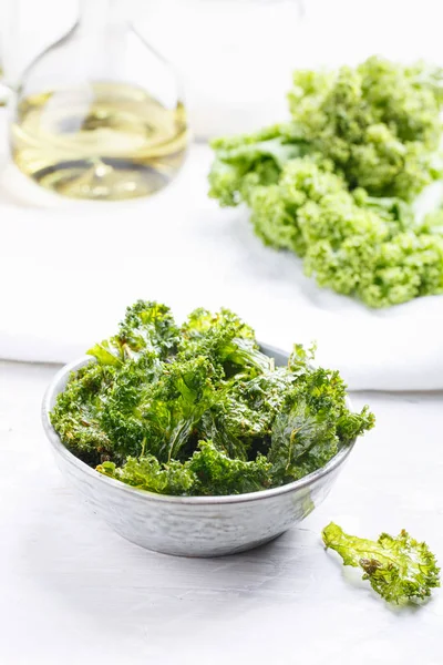 Batatas fritas de couve na tigela. Batatas fritas verdes crocantes desidratadas com sal — Fotografia de Stock