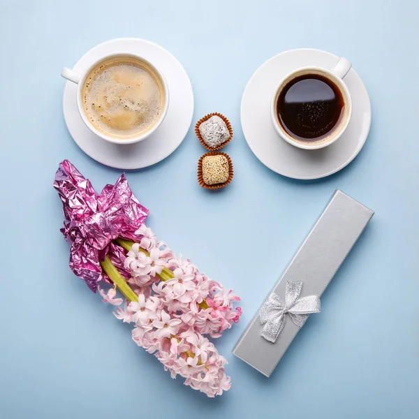 Fleurs de jacinthe rose, boîte cadeau et deux tasses de café sur bleu b — Photo