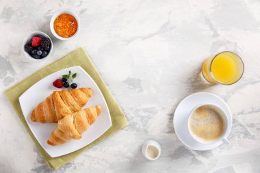 Kahvaltıda kruvasan, kahve, portakal suyu ve böğürtlen var. Uzayı kopyala Üst görünüm.