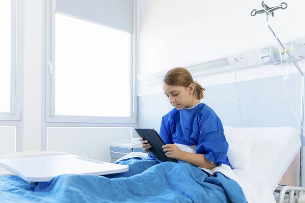 Paciente menina usando um tablet pc no hospital — Fotografia de Stock