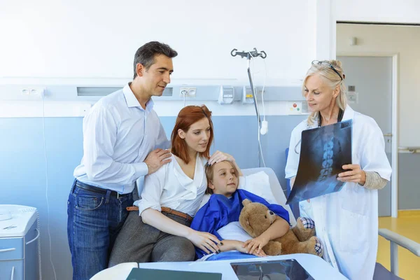 Pediatr návštěvu rodičů a dítě v nemocniční posteli — Stock fotografie
