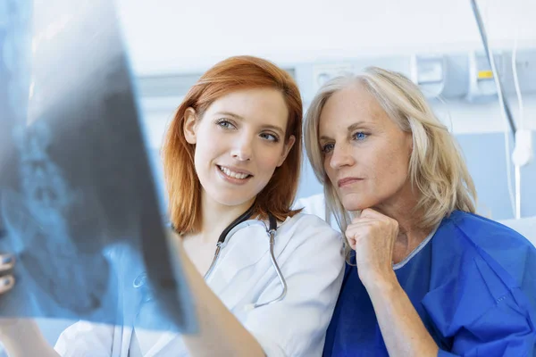 Läkare som visar röntgen för en äldre patient på sjukhus — Stockfoto