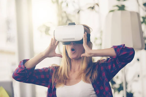 惊讶的女人看起来在一个虚拟现实的护目镜和打手势 — 图库照片