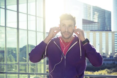 Şehirde çalışan kulaklıklar ile sporcu