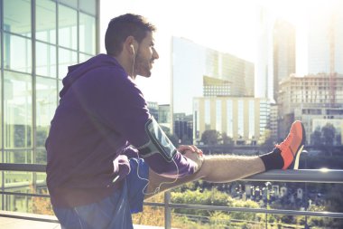 Egzersiz yaptıktan sonra bacaklarını esnetiyor ve koşu genç adam.