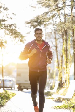 Şehirde çalışan kulaklıklar ile sporcu