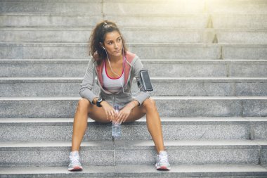Fitness kadın basamaklarında oturan çalışan bir mola.