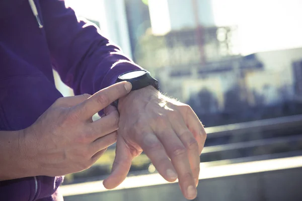 Corredor hombre comprobar la frecuencia cardíaca con reloj y entrenador — Foto de Stock