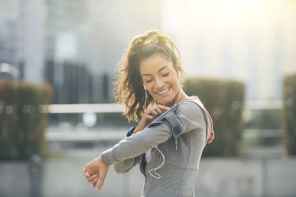 Coureur athlète écouter de la musique dans les écouteurs de téléphone intelligent — Photo