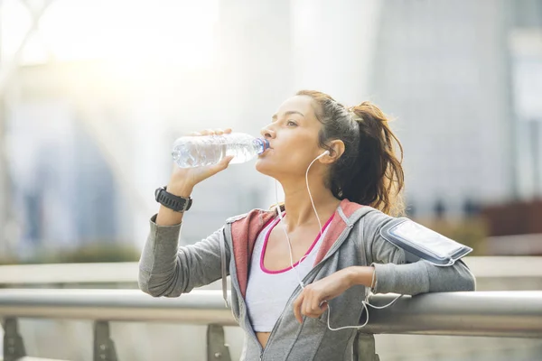 Femme coureuse fait une pause et boit de l'eau — Photo