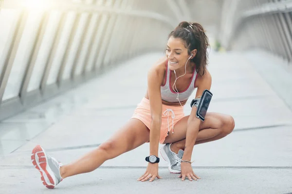 Jovem fitness mulher corredor alongamento pernas antes de correr — Fotografia de Stock