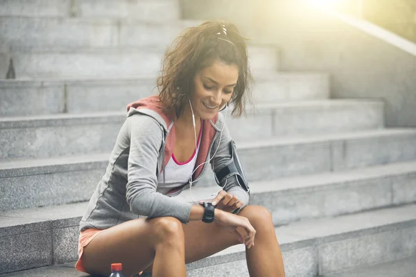 Une coureuse qui regarde sa montre de sport. Mesure de la fréquence cardiaque — Photo