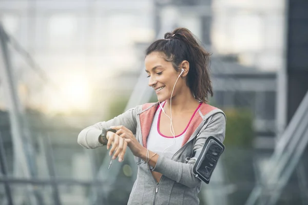 Une coureuse qui regarde sa montre de sport. Mesure de la fréquence cardiaque — Photo