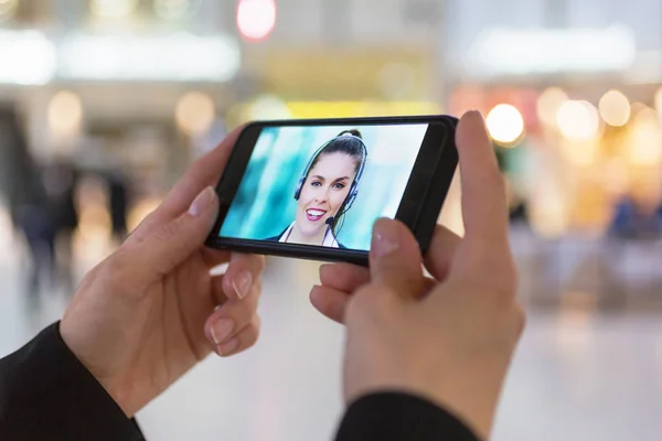 Close up de uma mão mulher segurando um smartphone durante um vídeo skype — Fotografia de Stock