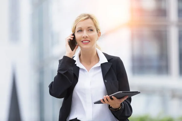 Businesswoman talking on mobile phone in financial district — Stock Photo, Image