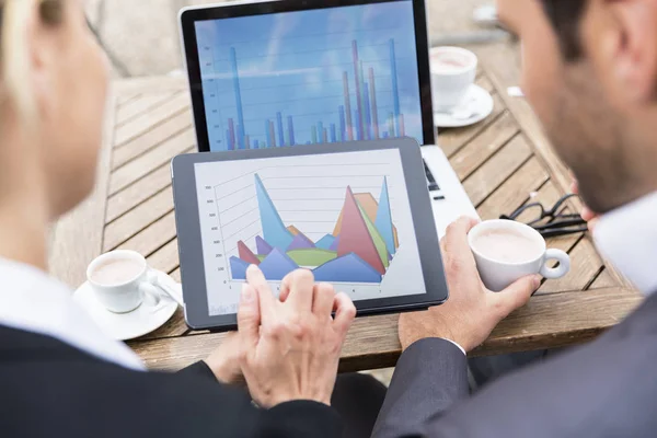 Gli uomini d'affari analizzano i dati finanziari durante una pausa caffè — Foto Stock
