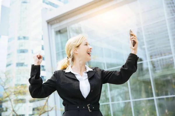 Businesswoman celebrating her success on the phone — Stock Photo, Image