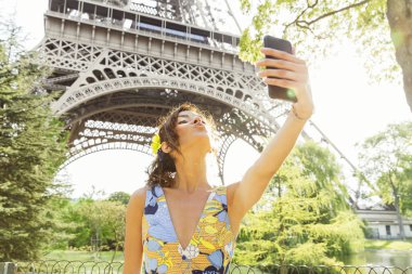Genç kadının bir selfie arka planda Eyfel Kulesi ile yapması