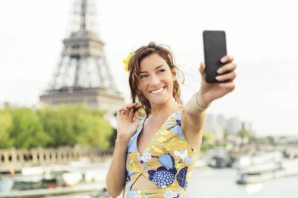 Woman doing a selfie in Paris with Eiffel tower in background — Stock Photo, Image