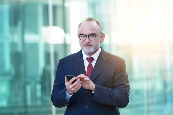 Uomo d'affari maturo utilizzando uno smartphone — Foto Stock