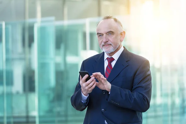 Uomo d'affari maturo utilizzando uno smartphone — Foto Stock