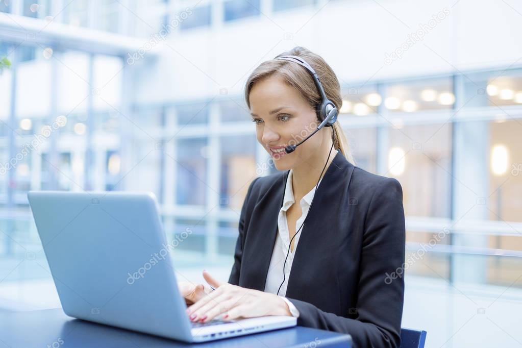 Portrait of a smiling Businesswoman using a head set