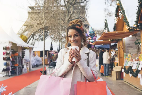 Mulher visitando um mercado de natal parisiense com Torre Eiffel em — Fotografia de Stock