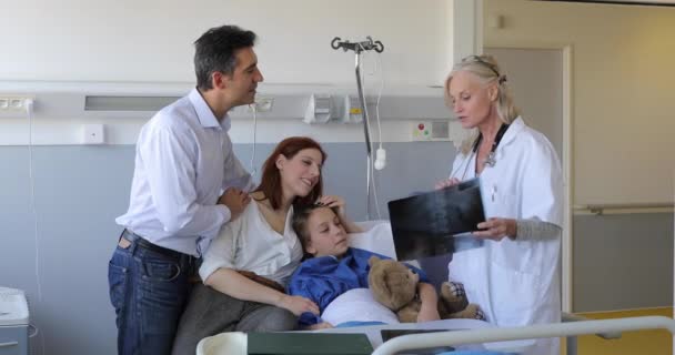 Pediatra visitando a padres e hijos en cama de hospital — Vídeos de Stock