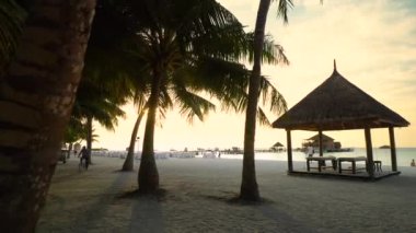 Günbatımında Maldivler 'de tropik bir ada