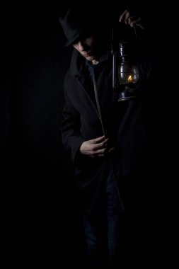 Bir gaz lambası ile şapkalı bir adam