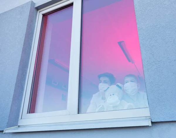 Barn med skyddsmasker som går genom fönstret — Stockfoto