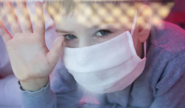 Ребенок в защитных масках, заглядывающий в окно — стоковое фото